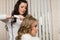 Female hair stylist girl makes hair styling