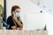 Female hairdresser answering the phone to give her clients an appointment, wearing a protective mask