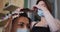 Female hairdresser dying hair of female customer wearing face mask at hair salon