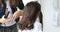 Female hairdresser standing and making hairstyle to cute lovely young asian teen in beauty salon