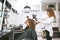 Female hairstylist drying curly girl`s hair using big plastic brush.