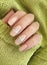 Female hand beautiful acrylic manicure nail sweater