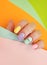 Female hand beautiful fashion   creativity   modern stylish multicolored manicure on a colored background