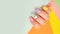 Female hand beautiful modern stylish multicolored manicure on a colored background