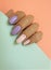 Female hand beautiful stylish summer delicate pastel manicure on a colored background
