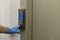 A female hand in a blue latex glove presses an elevator button in a residential apartment building. Antibacterial protection.