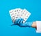 Female hand with blue sterile gloves holds a stack pills in a blister