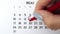 Female hand circle day in calendar date with a red marker. Business Basics Wall Calendar Planner and Organizer. May 13th