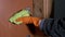 Female Hand Cleans Door Handle, Wipes Dirt with Microfiber Rag in Rubber Gloves