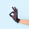 Female hand in cosmetology medicine black glove pointing up okay, yes, accepting hand sign to the side, studio shot, copy space,