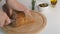 female hand cuts bread on the table with rosemary, olives and olive oil. Freshly baked Italian Bread, sliced with a