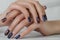The female hand with dark blue glittered nails. Hand of the girl. Female manicure.