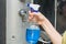 In a female hand a detergent close-up with a spray bottle on the background of a shower cabin. The idea is to keep the house clean