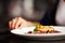 Female hand with a dinner at restaurant