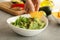 Female hand dips chips slice in guacamole, close up