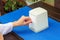 Female hand of the European model. A girl sits in a restaurant outdoors and takes a napkin. The napkin stands on a wooden table,