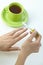 Female hand filing nails over cup of tea