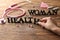 Female hand forming text WOMAN HEALTH on wooden table