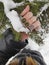 Female hand with Fresh polished green gray manicure nails holding snowy fir treen branch in winter, beauty