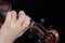 Female hand on fretboard violin. Fingers clamp the strings. For coverage of music news. Close up. Black background.