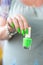 Female hand with green manicure with bottles of nail polish