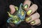 Female hand with green nail design. Multichrome shimmer Halloween nail polish manicure