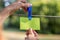 Female hand hanging a blank green card with plastic peg