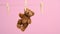 Female hand hangs on a rope behind the ear of a small brown teddy bear