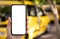 female hand hold phone with  screen background yellow taxi