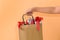 Female hand holding blank brown papaer shopping bags full of gift boxes ornamented