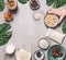 Female hand holding bowl with cashew on concrete background with vegan gluten-free cake ingredients: non dairy milk, almond flour