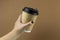 female hand holding a Ccoffee paper cup