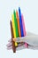 Female hand holding color markers, blue, yellow, green, pink, orange, brown