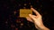 Female hand holding gold card on sparkling background, wealthy life, VIP club