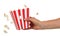 Female hand holding large square box popcorn on white.