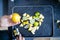 Female hand holding a lemon above slices of limes and lemons