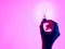 Female hand and holding luminous light bulb. Electric incandescent light bulb in hand on purple background. Inspiration Ideas conc
