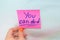 Female hand holding a pink sticker that says you can do it on a blue background