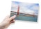 A female hand holding an postcard about the Golden Gate Bridge, the symbol of San Francisco city - California - USA