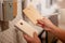 Female hand holding the sample color plate of wood door for  set up inside house at the Home department store