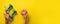 Female hand holding sweet donut, measuring tape, dumbbells over yellow background. Top view, flat lay. Weight lost, sport, fitness