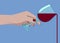 Female hand holding transparent glass with pouring red wine isolated on blue