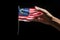 Female hand holding USA flag isolated on black background with clipping path, Hand holding Small Malaysia Flag, AI Generated