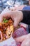 Female hand holding a vegetarian taco above a plastic basket