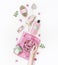 Female hand holding water bowl with pink flowers on white desktop with various eco friendly spa and skin care tools and cosmetic