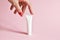 Female hand holding white cosmetic product tube. Blank plastic container for cream, lotion, toothpaste, nourishing or moisturizing