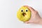 Female hand holding yellow donut with eyes. Funny doughnut character