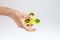 Female hand holding yellow fidget spinner on white back