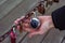 Female hand holds a combination lock fastened to a rusty chain next to other locks