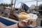 female hand holds fish sandwiches in the harbor in front of a fisherman's boat